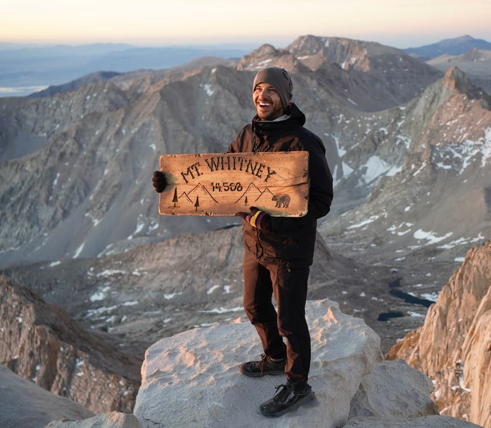 Atlas holding the carved Mt Whitney 14,508 sign on the summit