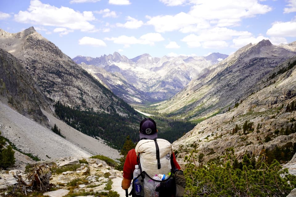 Atlas from behind with a white Hyperlite pack looking down a long High Sierra valley