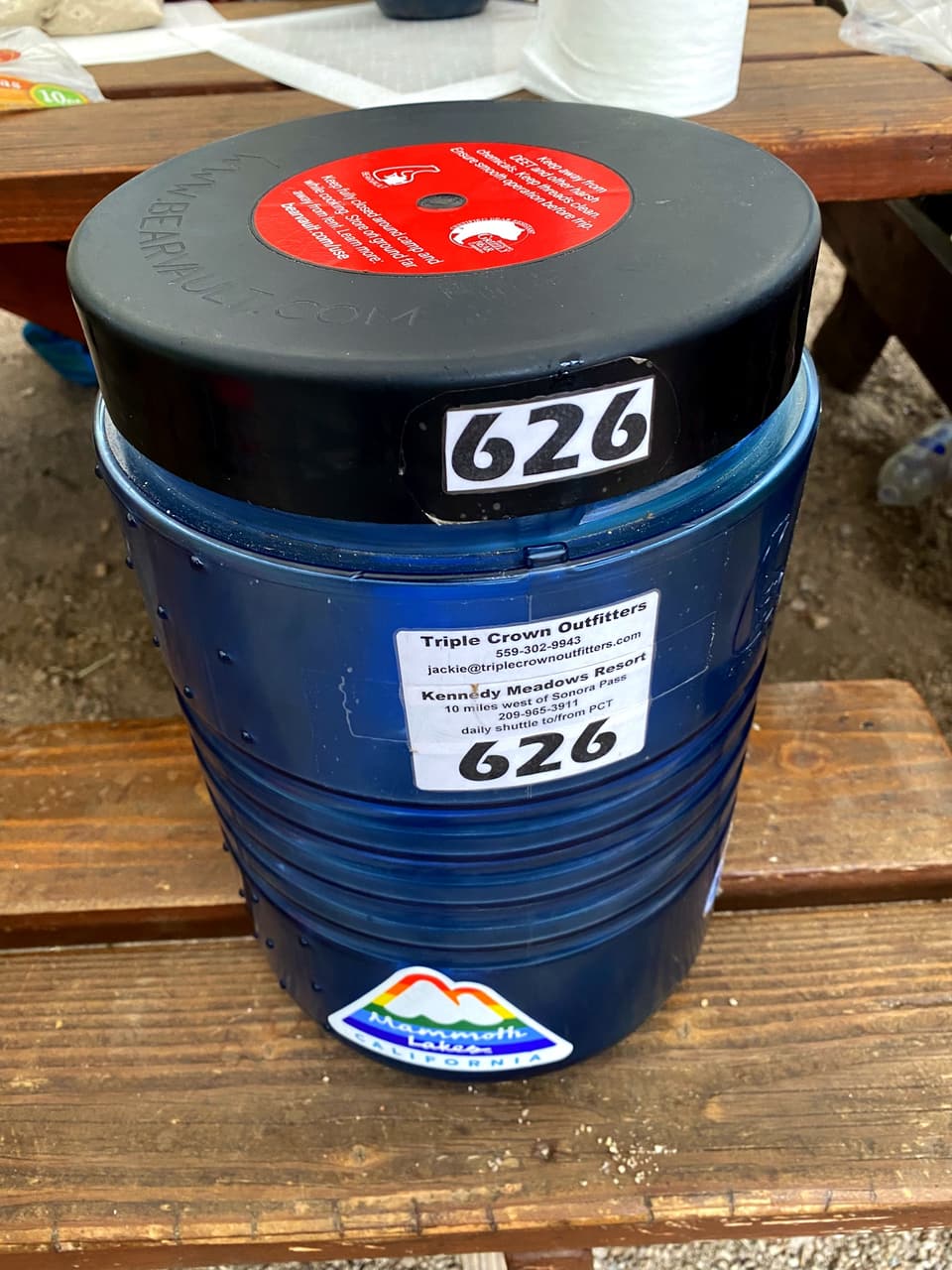 a rented blue BearVault bear canister numbered 626 on a picnic table