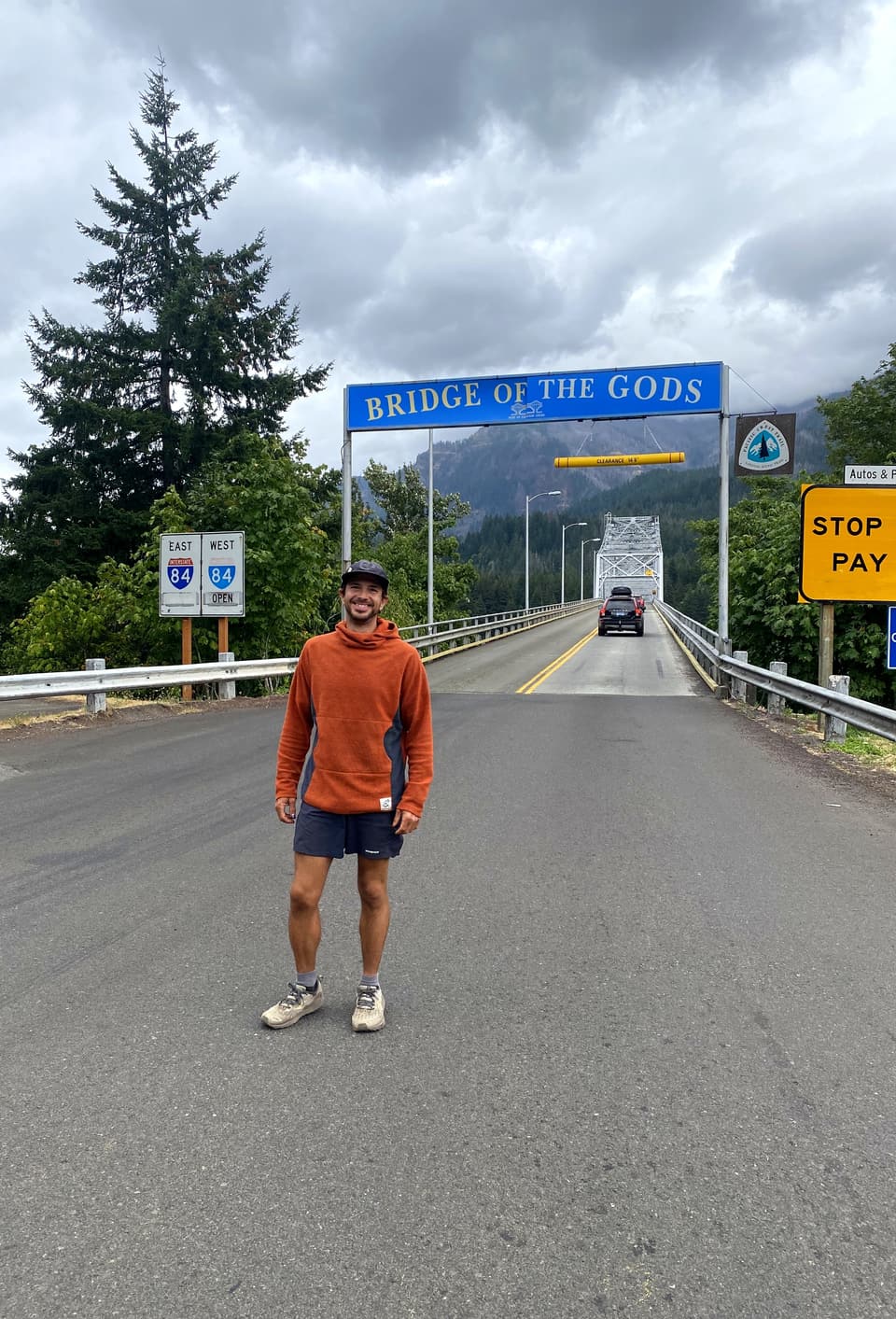 Atlas standing under the Bridge of the Gods sign, day 110