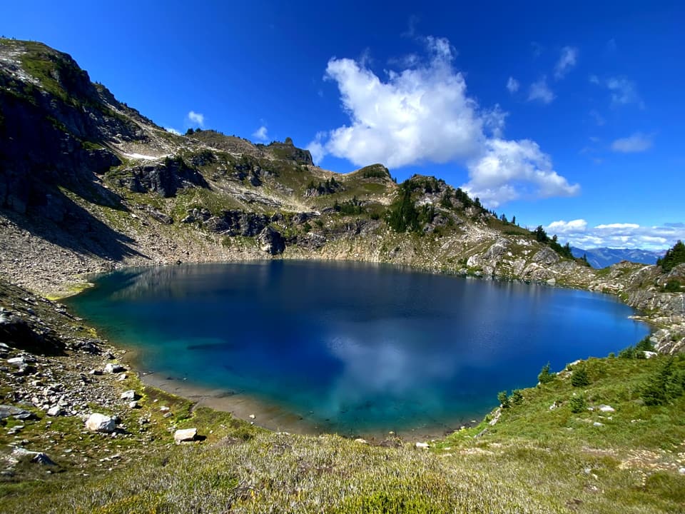 A blue alpine tarn in a rocky bowl in Glacier Peak country