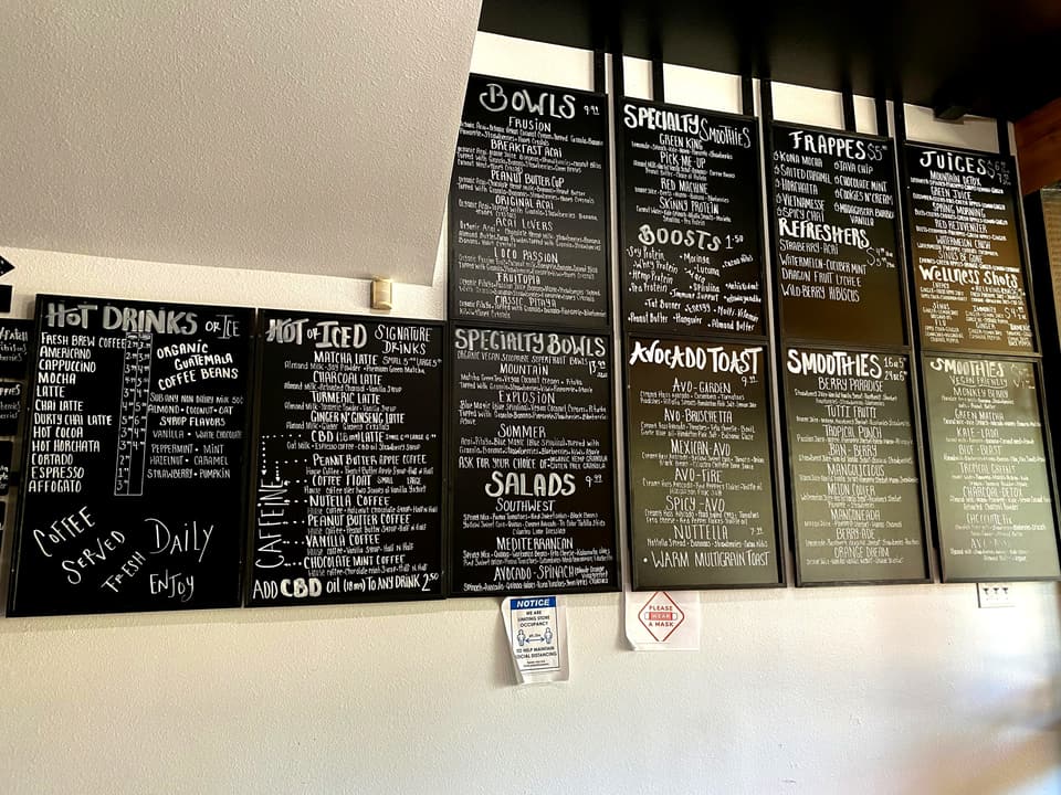 cafe menu board listing acai bowls, smoothies, juices and plant milks