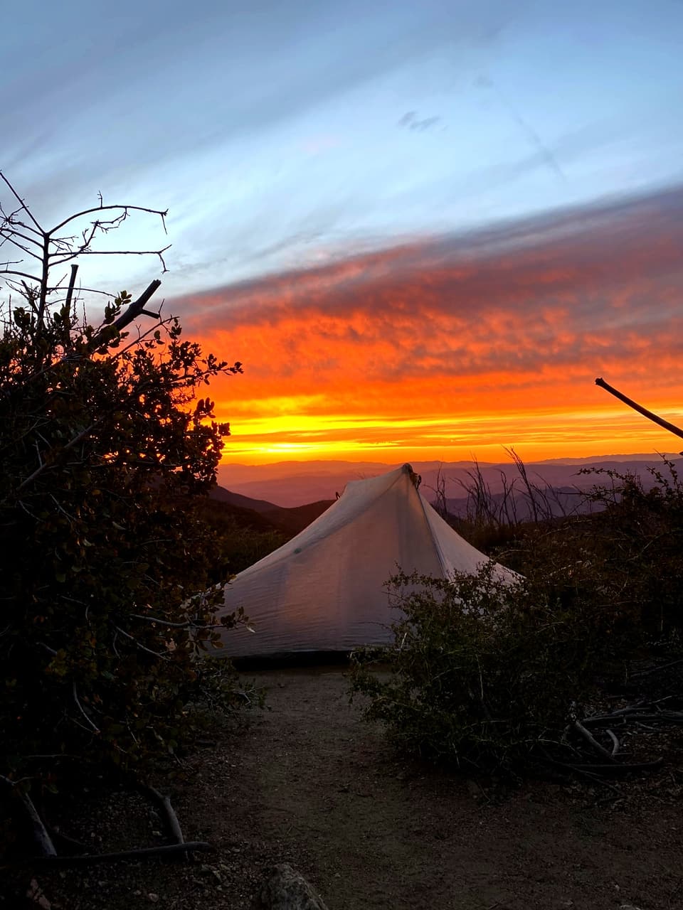 sunset above a tent, seen through another tent door