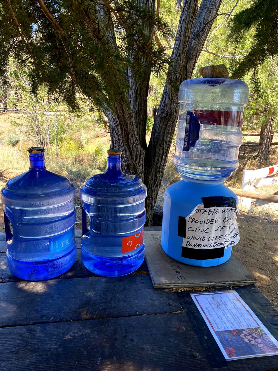 water jugs and a dispenser left for hikers