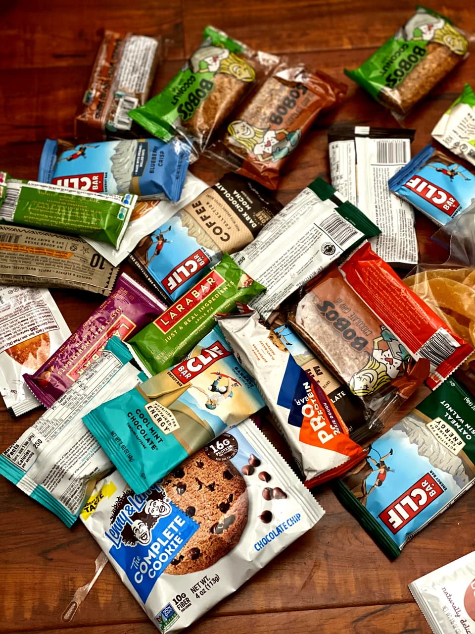 a table covered in Bobo's, Clif, Larabar, ProBar and Lenny & Larry's bars
